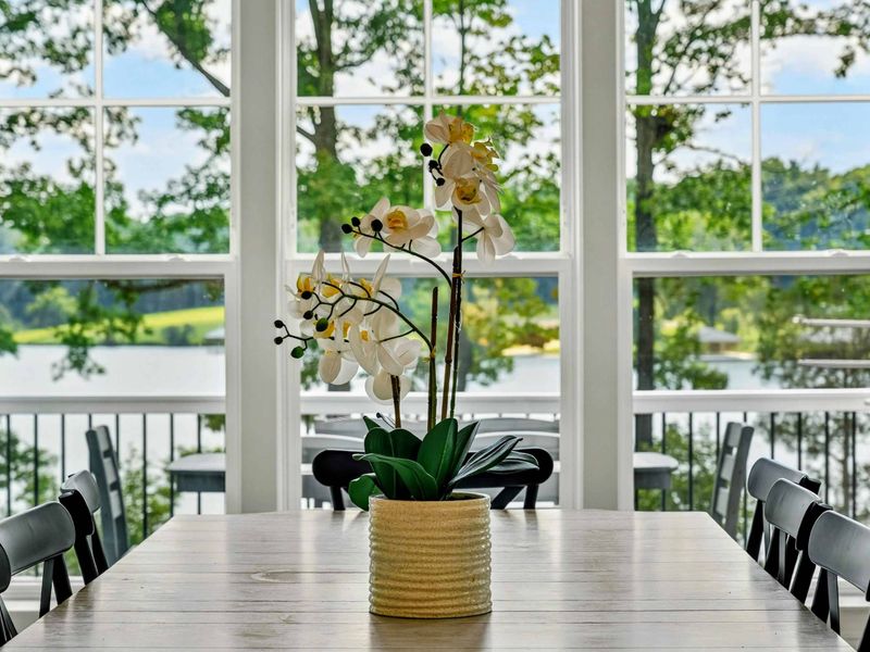 Dining Detail - An orchid centerpiece on the dining table, with the upper deck and the lake just outside the window.