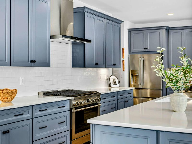 Kitchen Detail - Gas range, professional vent hood, and white quartz counters give serious cooks everything they need.
