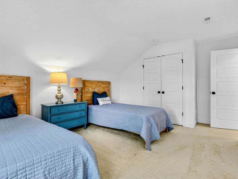 Twin Bedroom - The spacious twin room features closet storage, plush carpet, and a Welcome accent pillow for younger guests.
