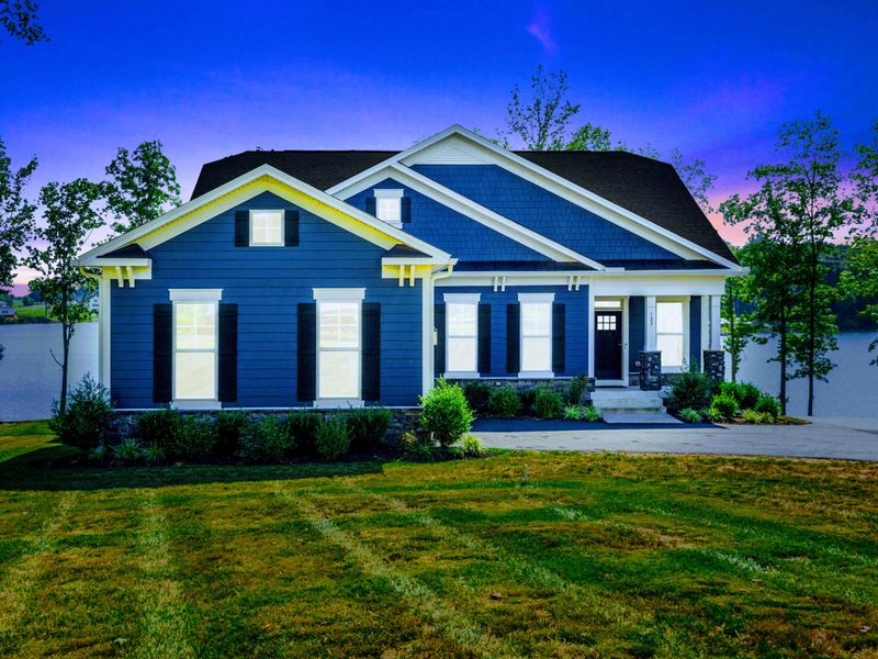 Twilight Exterior - The Shoreline's blue Craftsman facade glows at dusk under a violet sky, with the lake just out of frame.