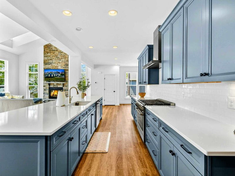 Kitchen & Dining - The oversized island stretches toward the dining room and great room with the fireplace in view.