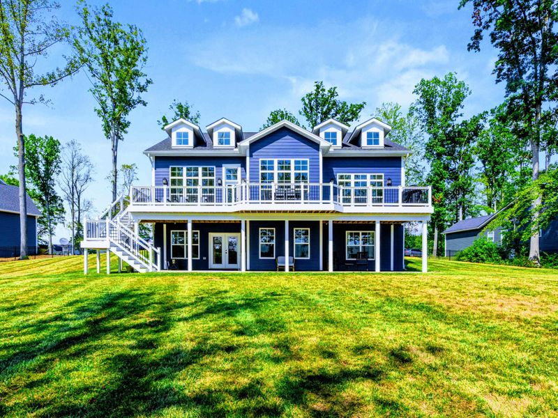 Rear Exterior - Three levels of light-filled living open to wraparound Trex decks and a covered lower porch with lake views.