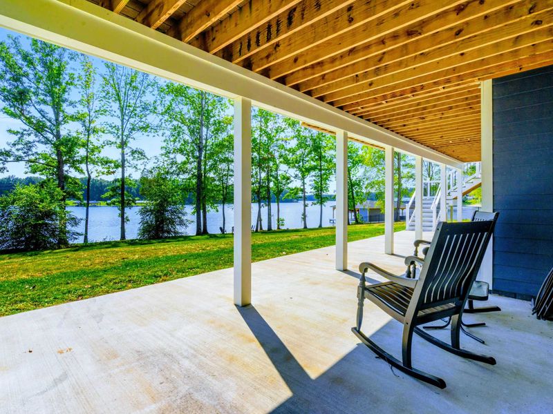 Lower Covered Porch - Rocking chairs and concrete patio under the deck offer a shaded retreat with full lake views.