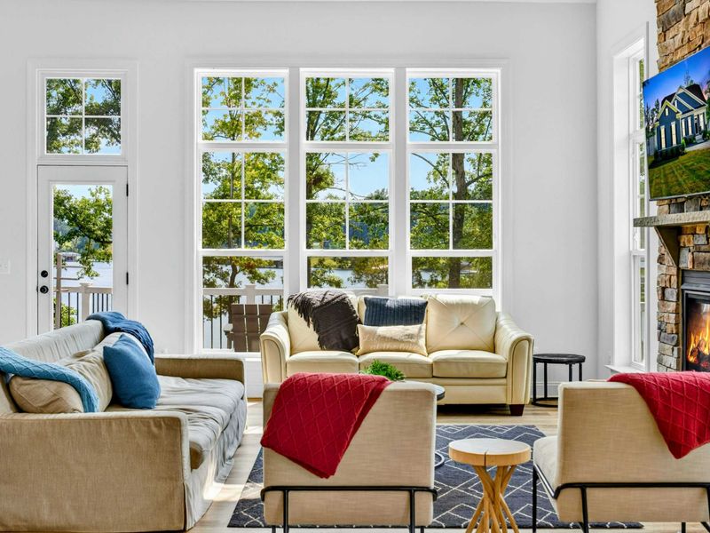 Great Room - Cream sectional, blue accent pillows, and a wall of large windows looking straight to the lake.