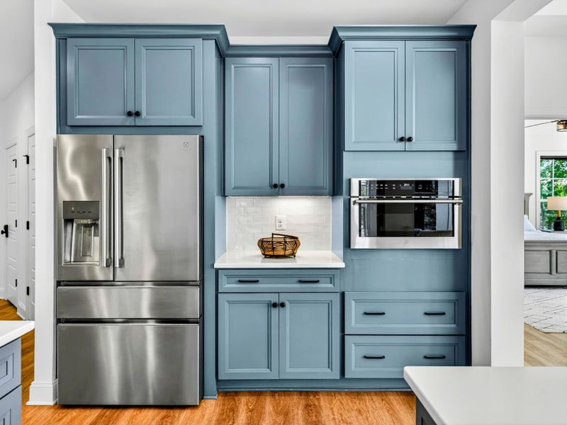 Kitchen Appliances - Stainless steel French-door refrigerator and built-in wall oven tucked into custom slate-blue cabinetry.