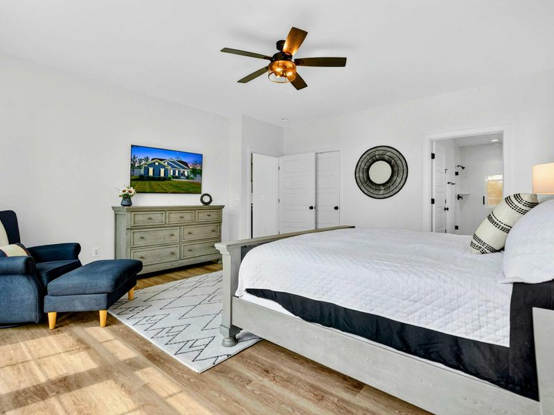 Lower Primary Suite - Another king bed with navy bedding, a Smart TV, and ensuite access just steps from the lower-level living area.