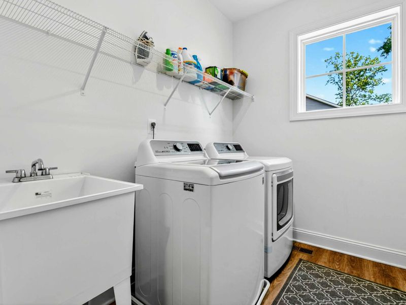 Laundry Room - Full-size top-load washer and dryer, utility sink, and storage shelving for easy after-the-lake cleanups.