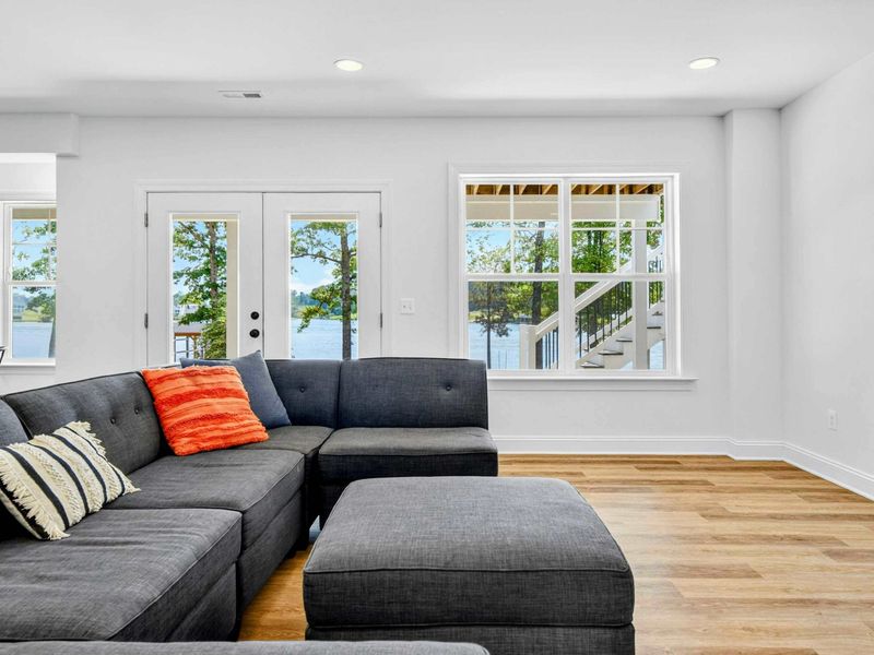 Lower Living Room - Bright lake views pour through windows and French doors that lead straight out to the lawn and lake.