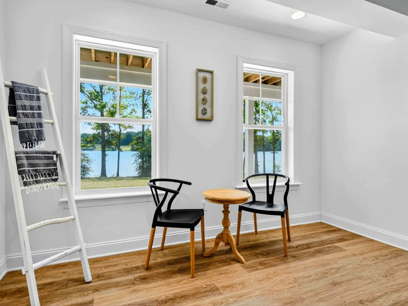 Lakeside Reading Nook - Two black wishbone chairs and a small table tucked beside the windows for quiet morning coffee with a view.