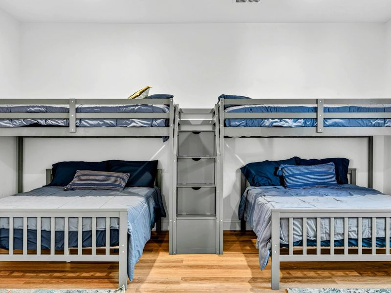 Bunk Room Detail - Close-up of the two full-over-full bunk sets with built-in staircase storage between them.