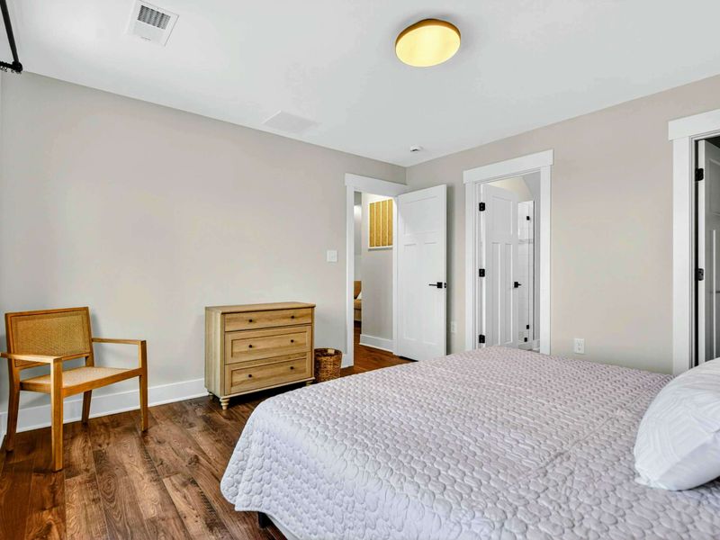 Bedroom 3 - Generous room with dresser, accent chair, private ensuite, and walk-in closet.