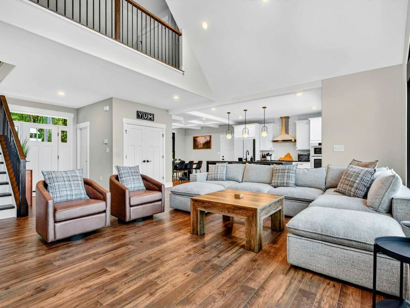 Great Room - Comfortable sectional and leather swivel chairs with the open kitchen visible beyond.