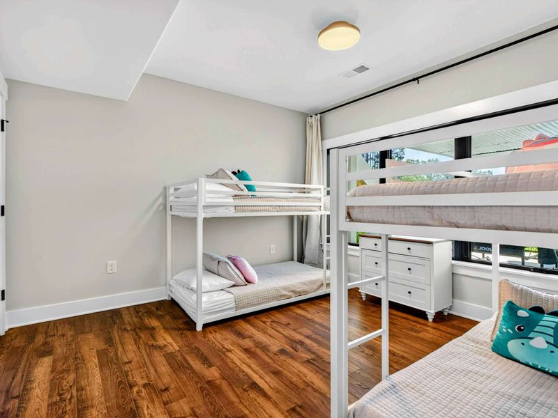 Bunk Room - Colorful pillows and cozy bedding on the white metal bunks, perfect for kids.