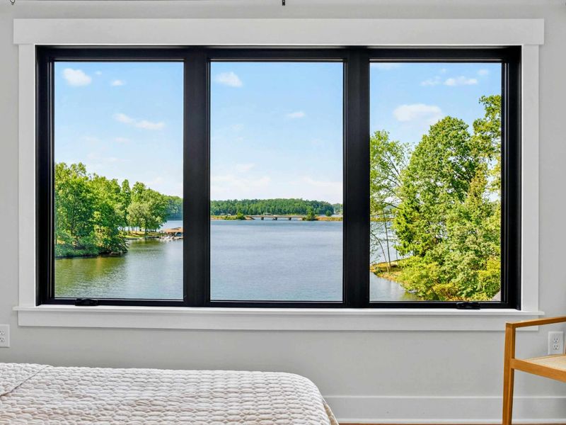 Bedroom 2 - Stunning lake view from the bed with the dock and distant shoreline in sight.