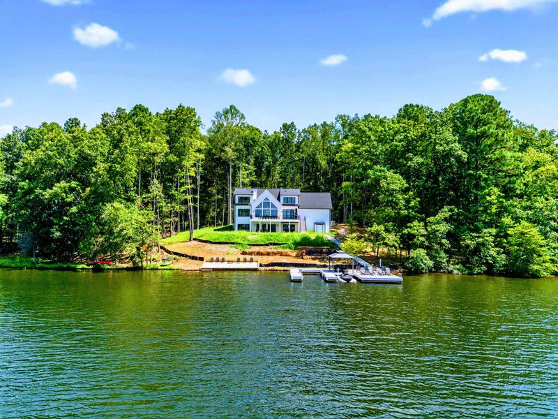 Waterfront - From the lake, the full property unfolds with the home, manicured hillside, and private dock.