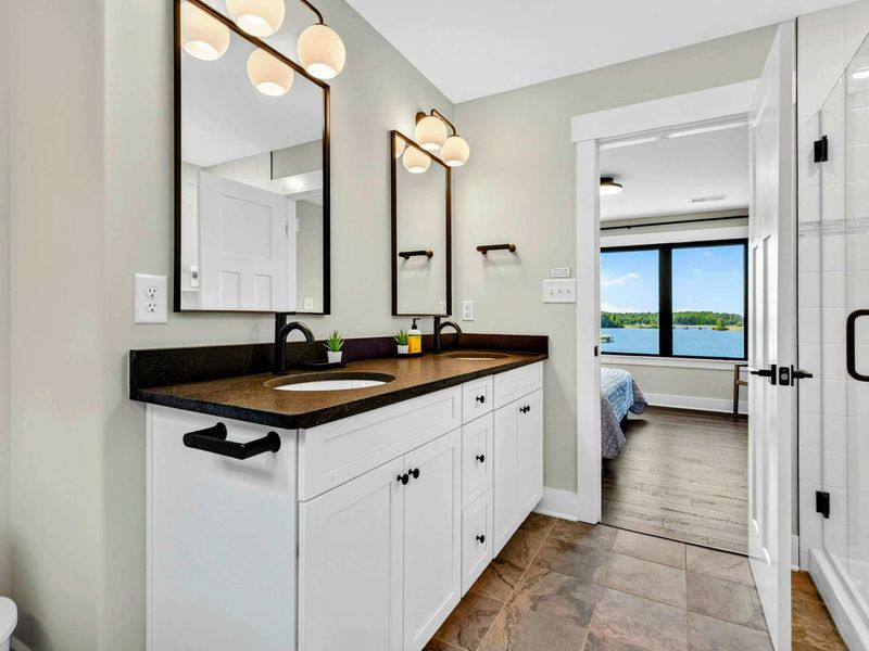 Bathroom 3 - Dual vanity and glass-enclosed shower create a spa-like ensuite retreat.