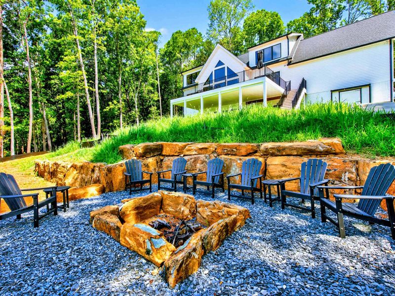 Fire Pit - Natural boulder fire pit surrounded by Adirondack chairs with the home as a backdrop.