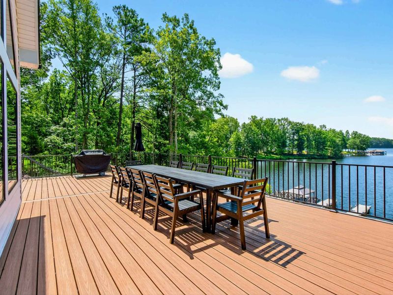 Main Deck - Dining and grilling area with glimpses of the lake through the tree canopy.