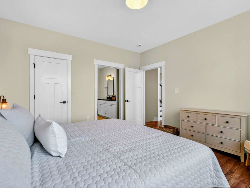 Primary Suite - Spacious layout with private ensuite bathroom, walk-in closet, and oak dresser.