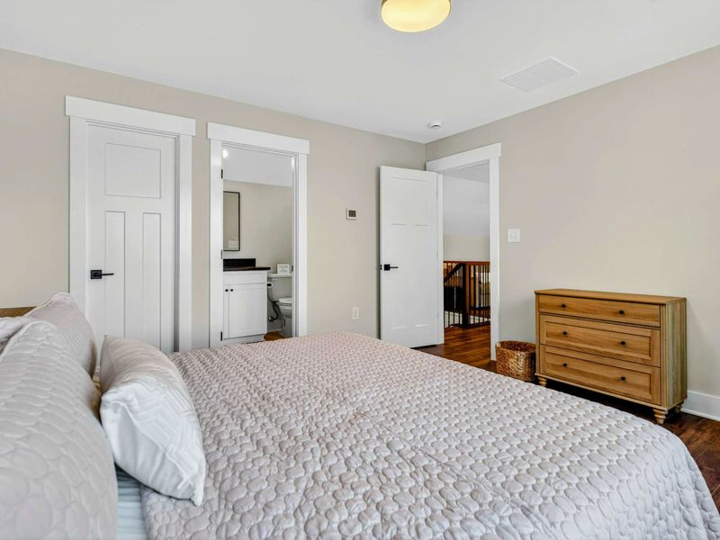 Bedroom 4 - Room view showing the ensuite entry, hallway, and oak dresser.