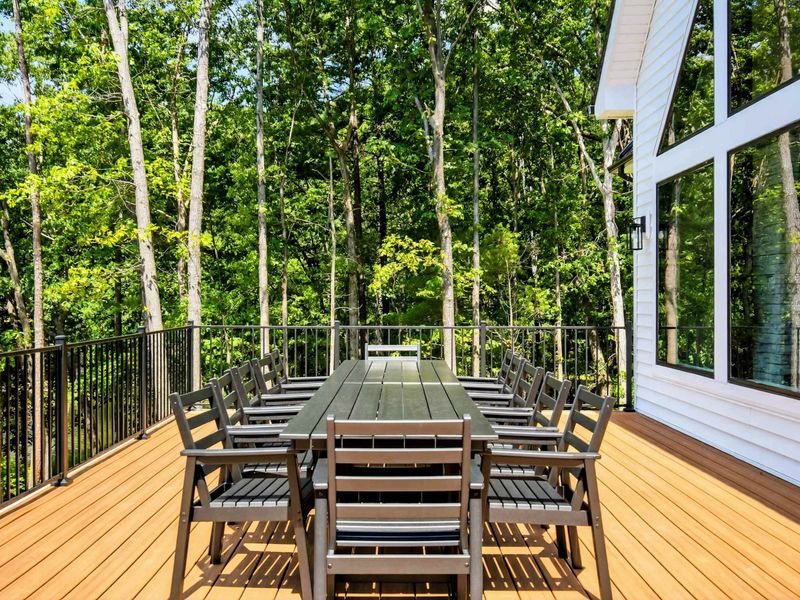 Main Deck - Outdoor dining table with lake views beyond the deck railing.