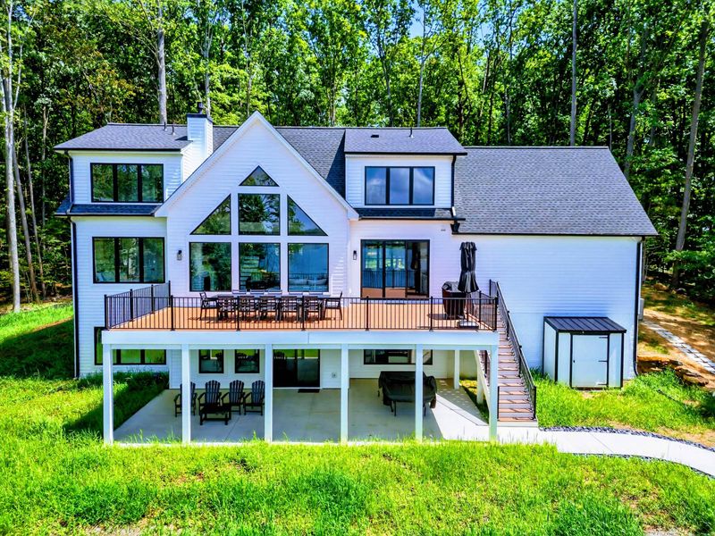 Rear Exterior - Modern A-frame design with floor-to-ceiling windows, expansive deck, and multi-level living.