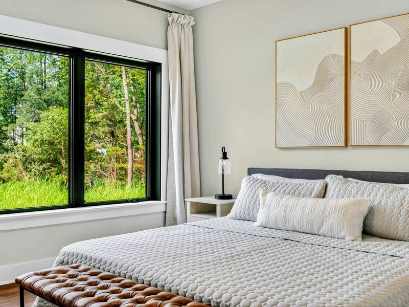 Bedroom 5 - Abstract art diptych above the bed with views of the lush green tree canopy.