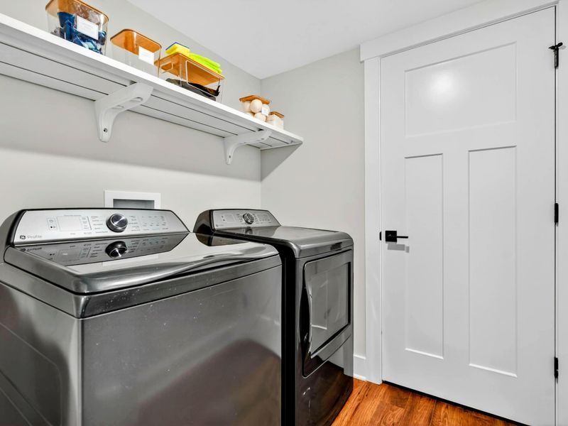 Laundry Room - Large capacity washer and dryer with overhead storage shelf for guest convenience.