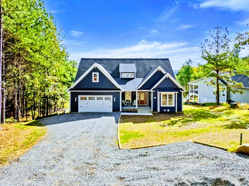Curb Appeal - The navy craftsman exterior with stone accents, a two-car garage, and a welcoming front porch.