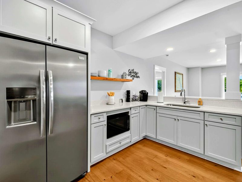 Second Kitchen - A full-size stainless refrigerator, gray cabinetry, microwave, quartz counters, and a coffee station make the lower-level kitchen self-sufficient.