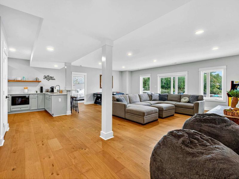 Lower Level Living - The spacious lower level with a large sectional, bean bag chairs, a second kitchen with coffee bar, and a "Getting Together" sign on the wall.