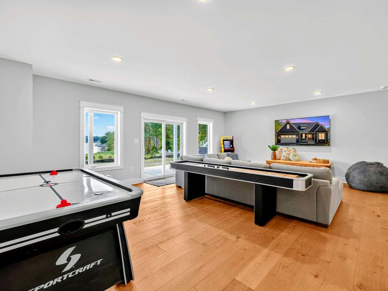 Rec Room - Air hockey, shuffleboard, an arcade cabinet, a sectional, and a wall-mounted Smart TV make the lower level a hub for all-day fun.