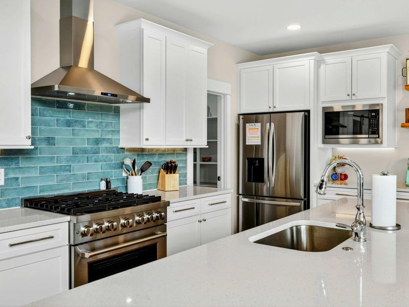 Kitchen Appliances -The stunning teal backsplash, stainless-steel appliances, and gleaming quartz countertops create a fresh, modern look with an elevated lake house vibe. Thoughtfully designed, this kitchen blends luxury and comfort in every detail!