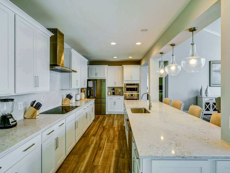 Large fully stocked kitchen with huge island, new stainless steel appliances, and large pantry.