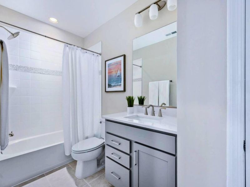 Lower Bath - Tub-shower combo, gray vanity, and a sailboat print on the wall keeping the lake theme going.