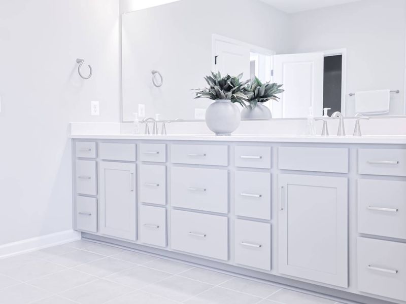 Primary Bath Vanity - Long quartz counter, dual sinks, and storage on both ends: no one's fighting for counter space in the morning.