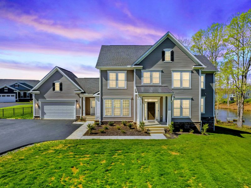 Exterior at Dusk - The front of the house catching the last of the evening light, with windows already glowing inside.