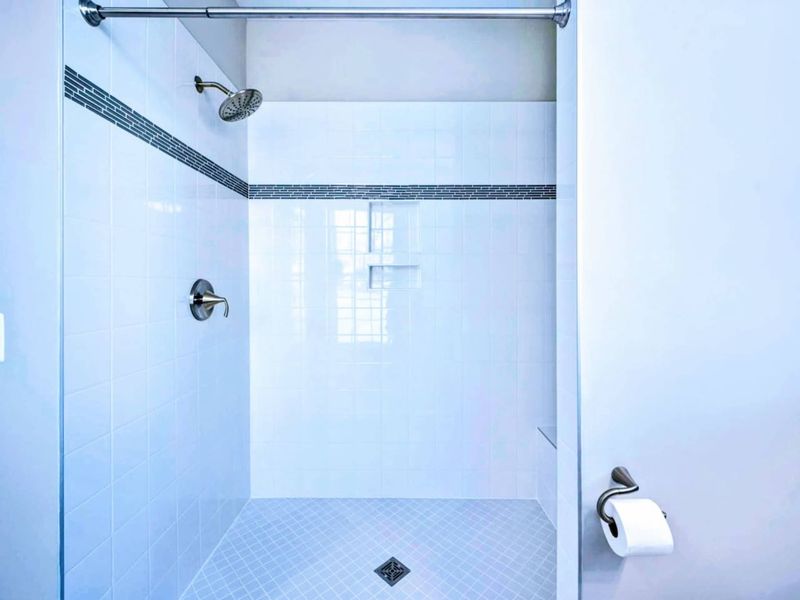 Shower Detail - Tile-on-tile walk-in shower with niche and rain head, designed to feel a little more spa than functional.