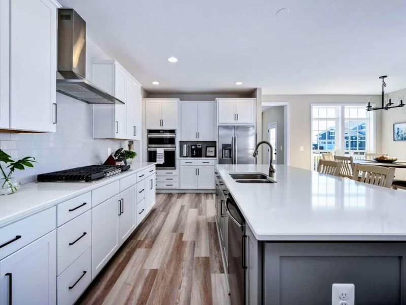 Kitchen - Long quartz island, full appliance suite, and a clear sightline straight through to the dining room.