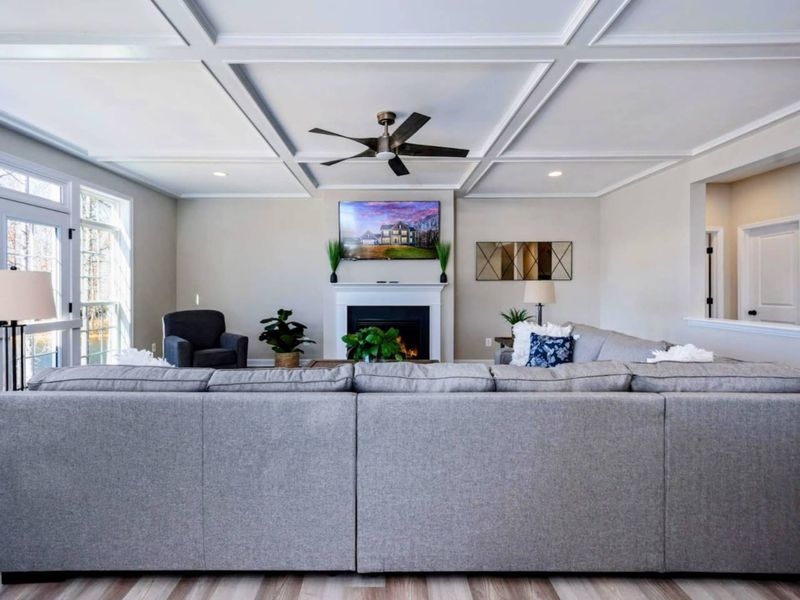 Great Room - Sectional facing the fireplace, coffered ceiling above, and an easy flow between cooking, eating, and lounging.
