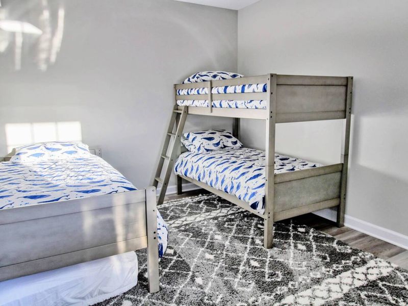 Bunk Room - Twin-over-twin bunks plus a third single, whale-print bedding, the room the kids will claim before they even unpack.