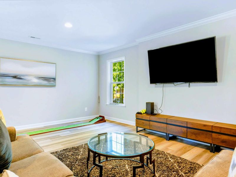 Game Room Lounge - Soft sectional and a big TV right next to the games, with a coastal-style painting setting the mood.