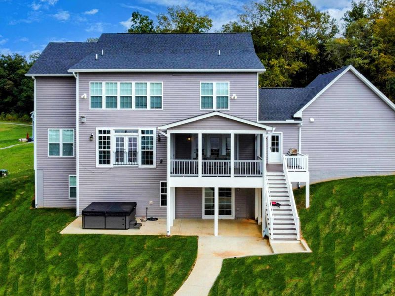 Back of House - Two stories of windows facing the lake, screened porch above, and the hot tub waiting on the lower patio.