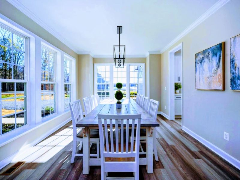 Dining Room - Long farmhouse table with seating for eight, lantern fixture overhead, and windows pulling in afternoon light.