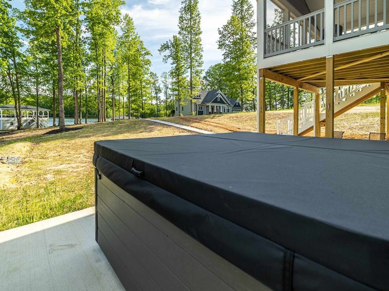 Relax in our tranquil outdoor space, featuring a private hot tub with scenic views of the surrounding lake and lush forest!