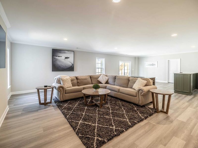 Relax in our spacious Basement Entertainment room featuring a plush sectional sofa, modern amenities, and elegant decor for a comfortable home-away-from-home experience!