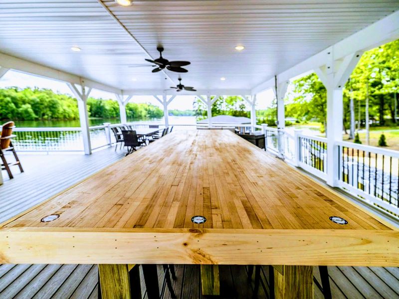 Dine and entertain in comfort on our expansive covered deck featuring a large rustic table and panoramic views of the lake