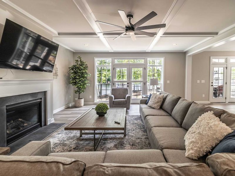 Indulge in lakeside living from an open-concept great room featuring a cozy gas fireplace, 4k smart tv, large couch, and seamless access to a picturesque patio boasting captivating views of Lake Anna.