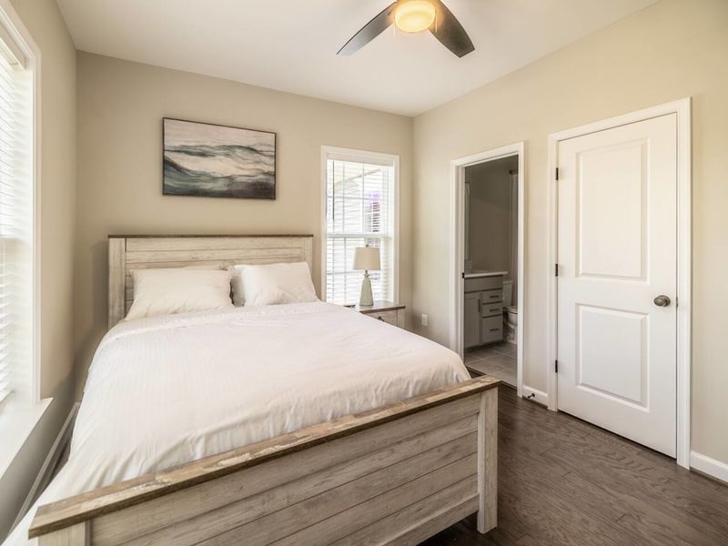 Freshen up in our sleek bathroom featuring a pristine bathtub, modern fixtures, and a well-lit vanity area for a relaxing and comfortable stay