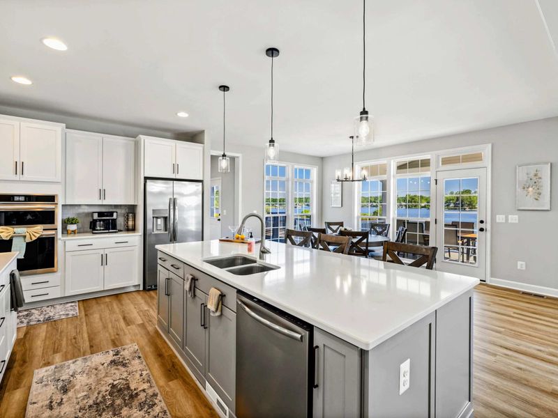 Our bright and spacious kitchen features a large island, modern appliances, and stunning lake views from the adjoining dining area.